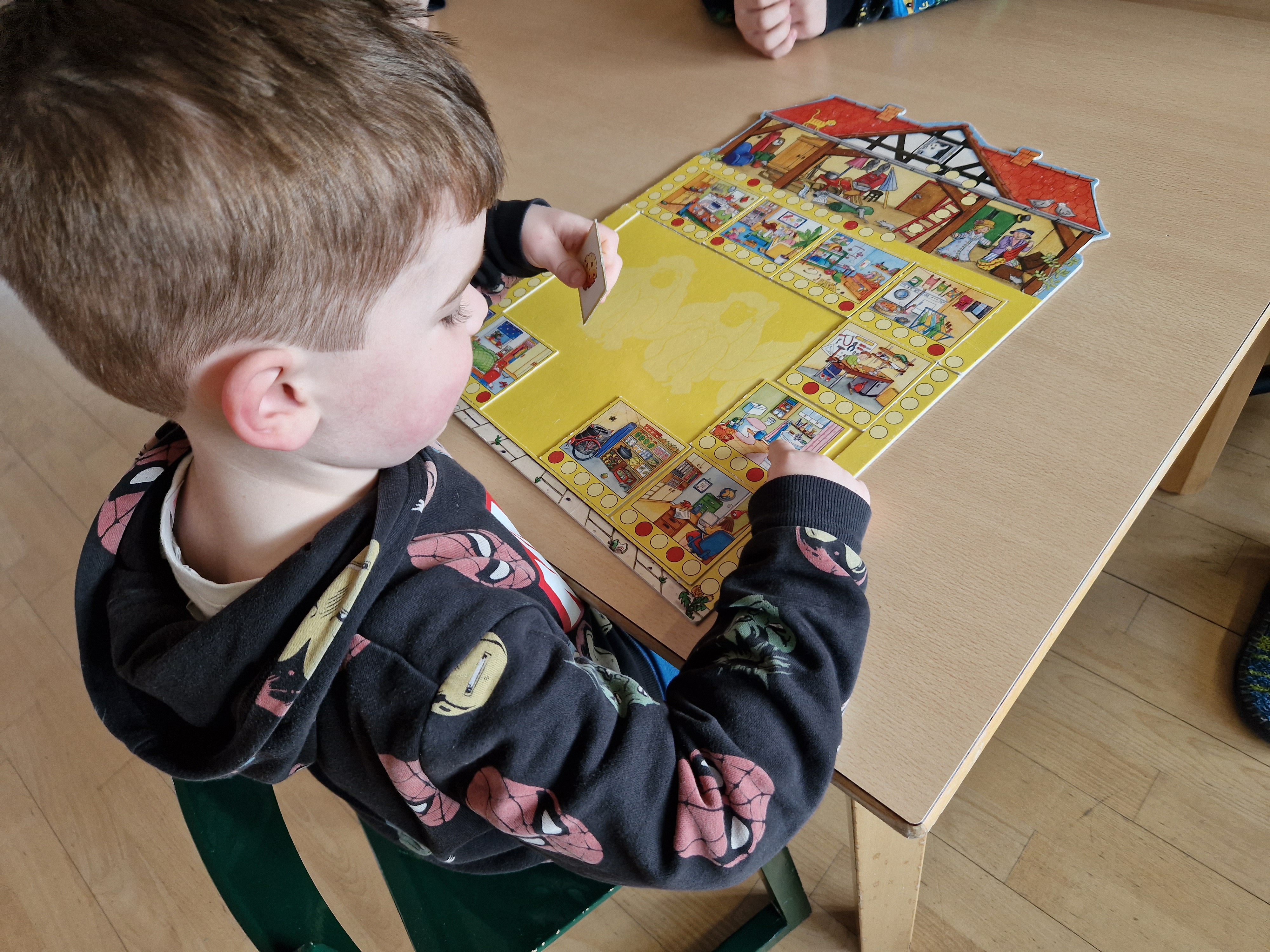 Kind spielt ein Brettspiel.