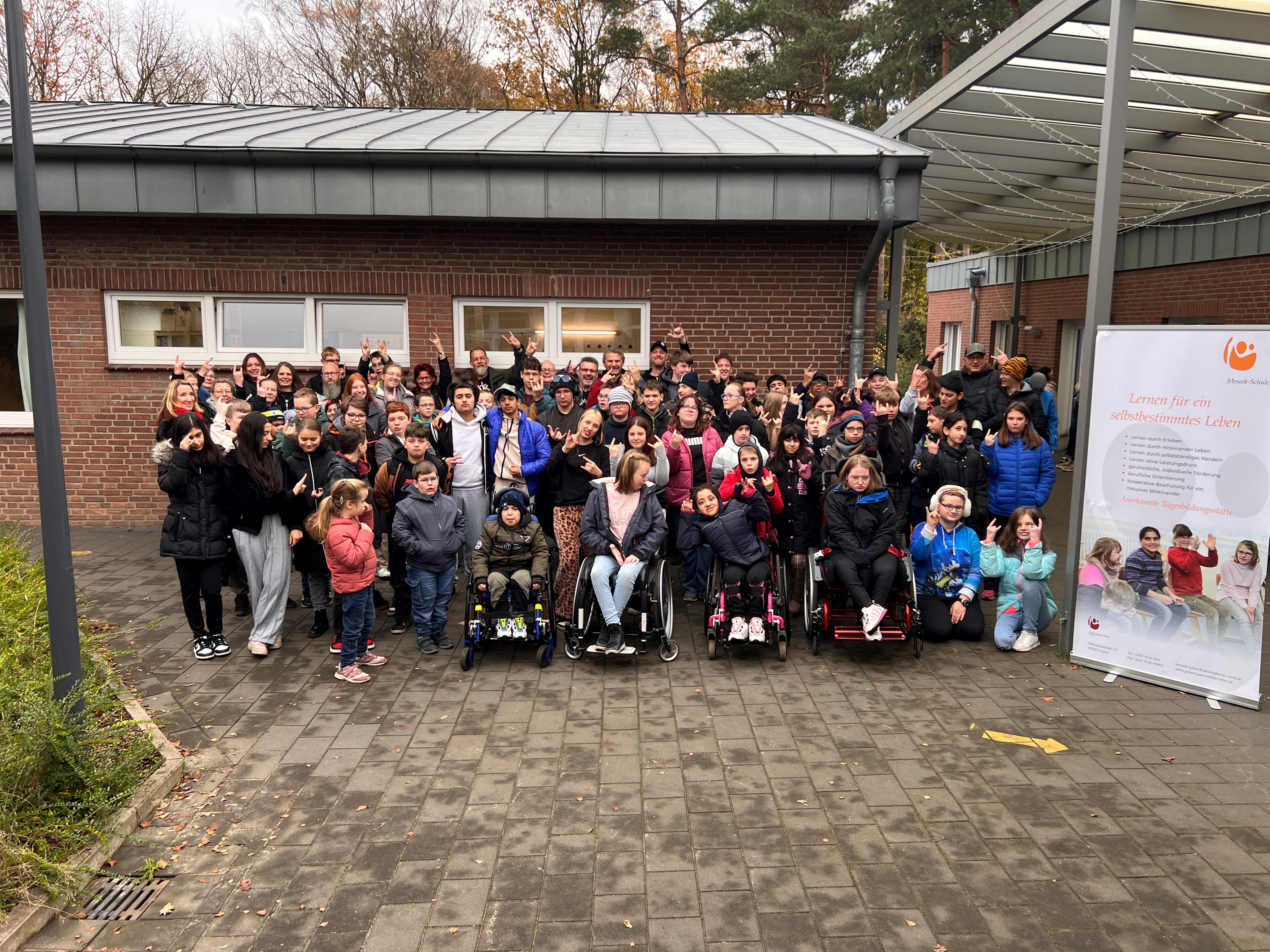 Großes Gruppenfoto vor der Mosaik-Schule