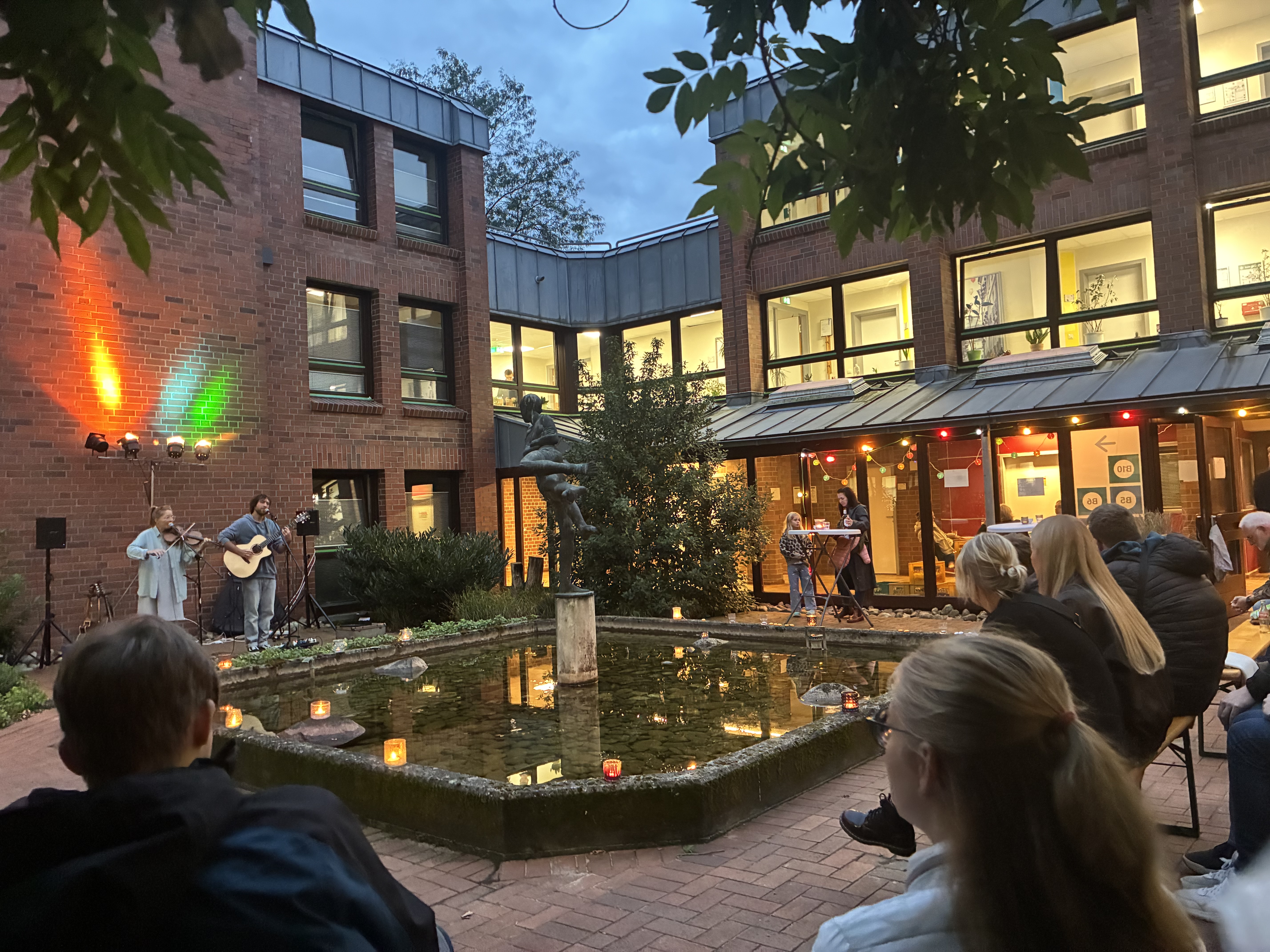 Musikerinnen spielen in einem Innenhof vor Publikum.