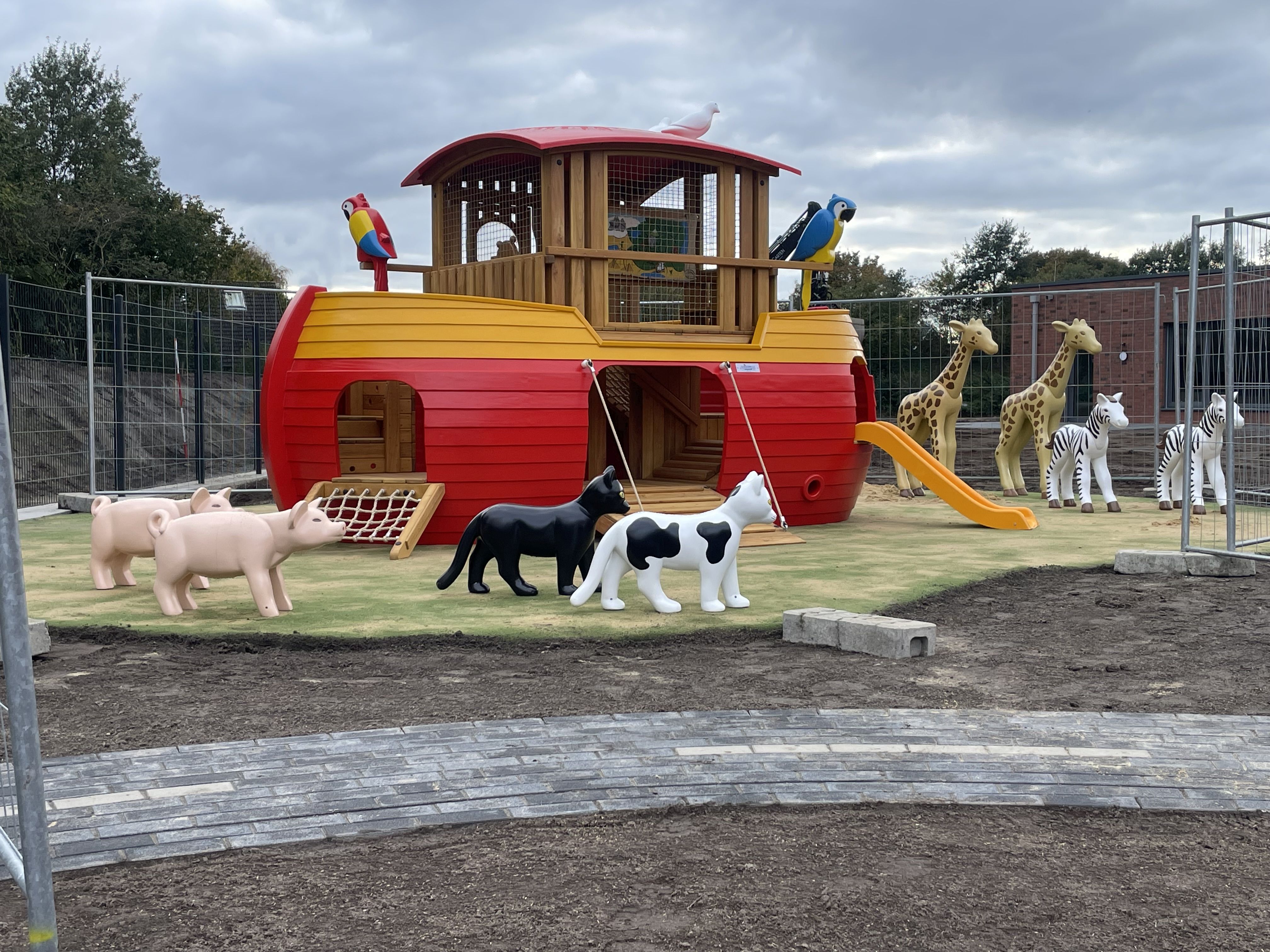 Die Arche steht auf dem Spielplatz, umgeben von Spielzeugtieren.