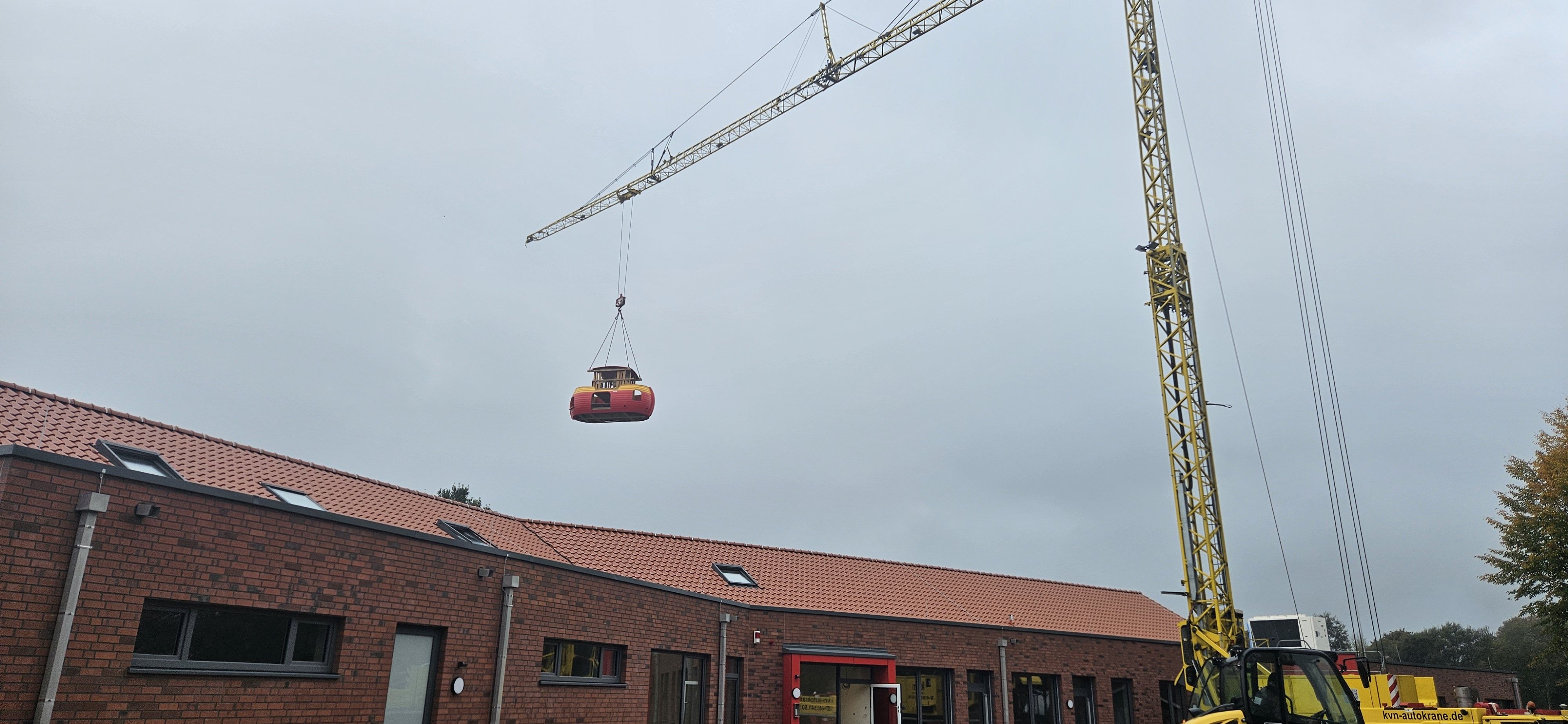 Die Arche schwebt an Ketten über dem Gebäude des Kindergartens