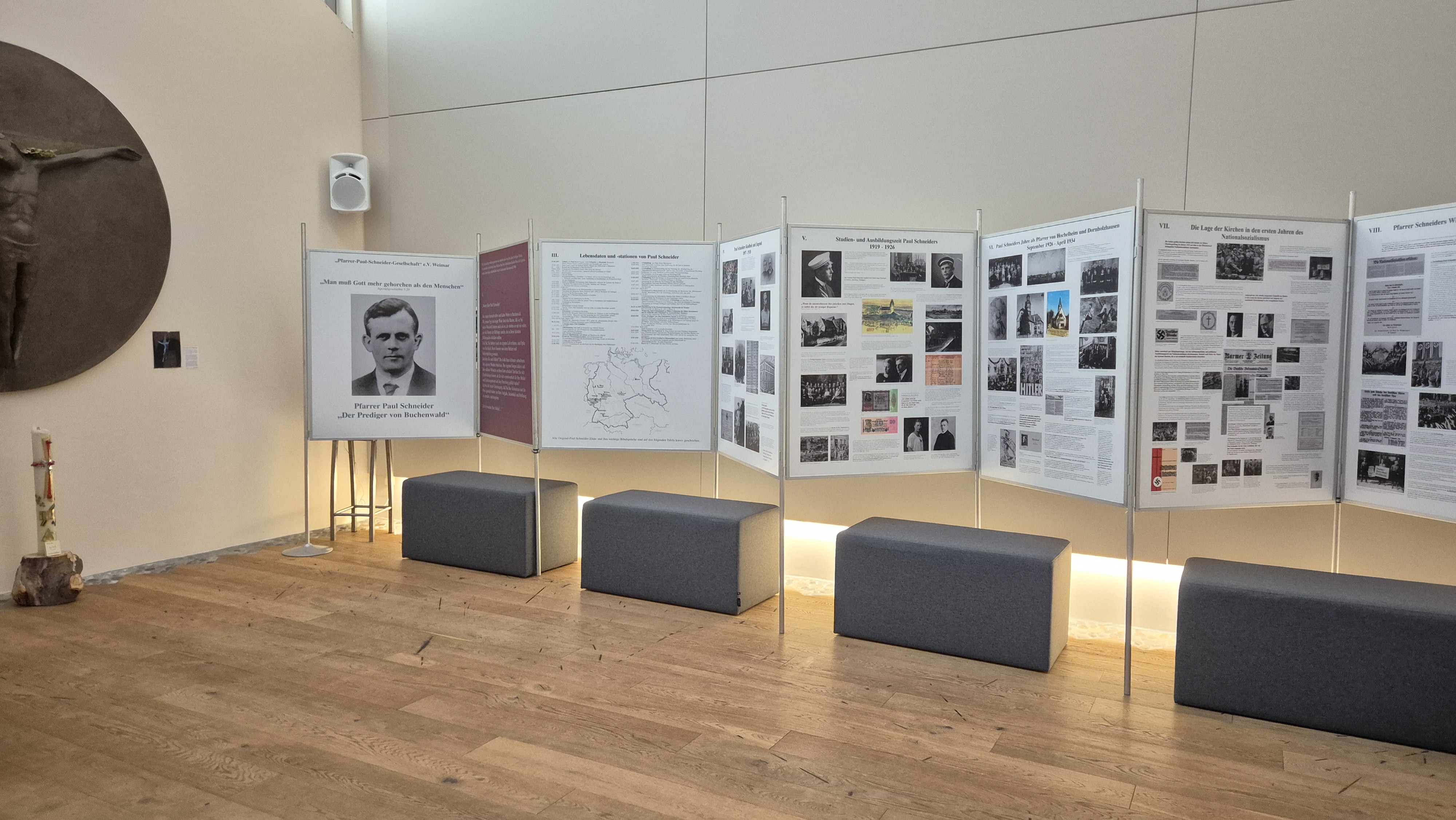 Es ist der Innenraum der Kapelle des Christophorus-Werkes zu sehen. An der Wand entlang stehen die Ausstellungstafeln mit Text und Bildern zu Pfarrer Paul Schneider.