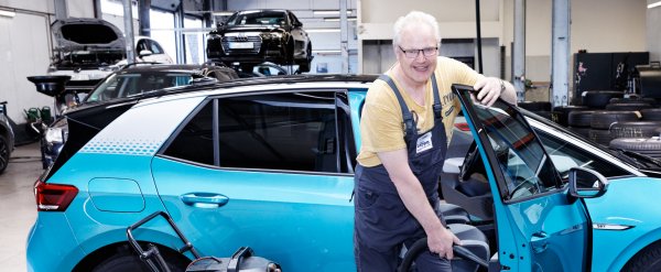 Teilnehmer reinigt ein Auto mit einem Staubsauger.