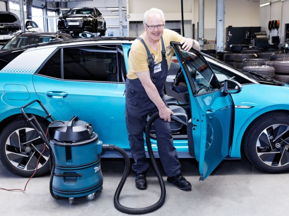 Teilnehmer reinigt ein Auto mit einem Staubsauger.