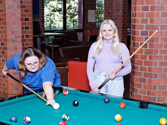 Zwei Auszubildende spielen Billard.