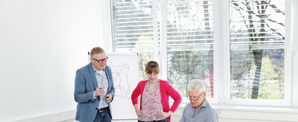 Drei Fachkräfte in einer Besprechung.