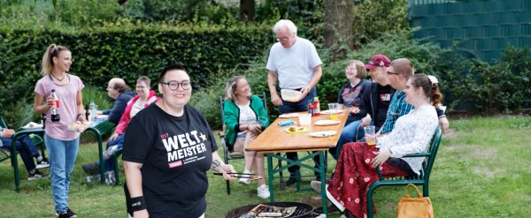 Freizeitgruppe beim Grillen im Garten.