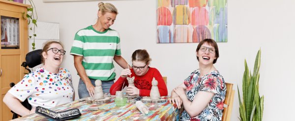 Drei Frauen sitzen am Tisch und töpfern Tier-Figuren.