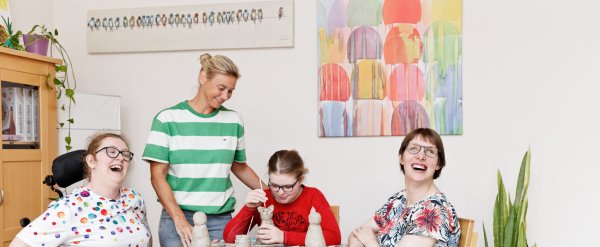 Drei Frauen sitzen am Tisch und töpfern Tier-Figuren.