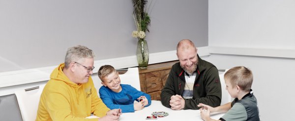 Mitarbeiter und Kinder spielen Karten.