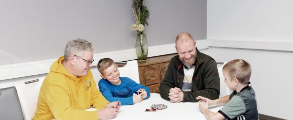 Mitarbeiter und Kinder spielen Karten.