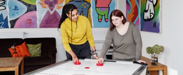 Zwei Jugendliche spielen Air-Hockey.