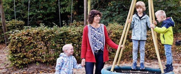 Mitarbeiterin mit drei Kindern an der Nestschaukel.