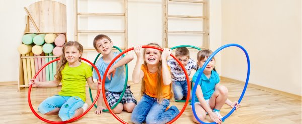 Kinder spielen mit bunten Hula-Hoop-Reifen.