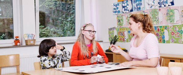 Mehrere Schülerinnen und Schüler geben sich auf dem Schulhof ein High-Five.