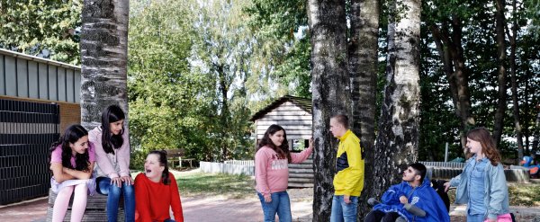 Schülerinnen und Schüler verschiedenen Alters auf dem Pausenhof.