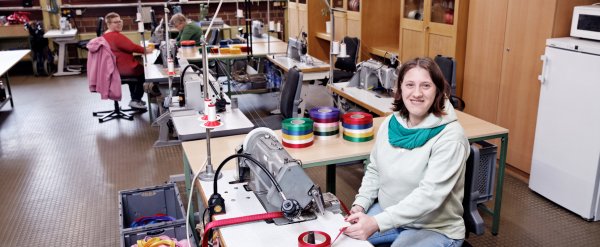 Beschäftigte an der Nähmaschine in der Schleifenwerkstatt.