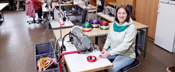 Beschäftigte an der Nähmaschine in der Schleifenwerkstatt.