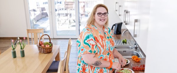 Bewohnerin schneidet Gemüse in der Küche.