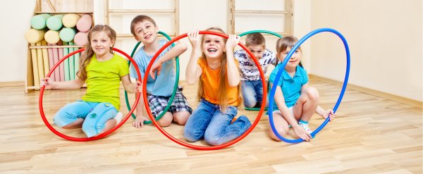 Kinder spielen mit bunten Hula-Hoop-Reifen.
