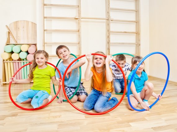 Kinder spielen mit bunten Hula-Hoop-Reifen.